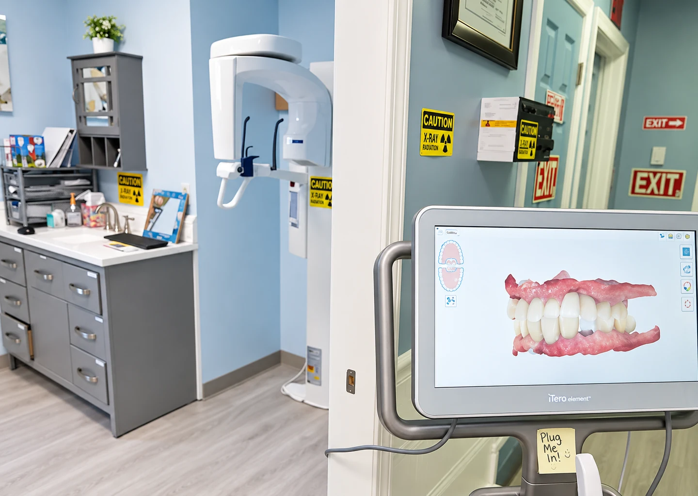 The panoramic x-ray unit beside a chairside screen showing an intraoral scan