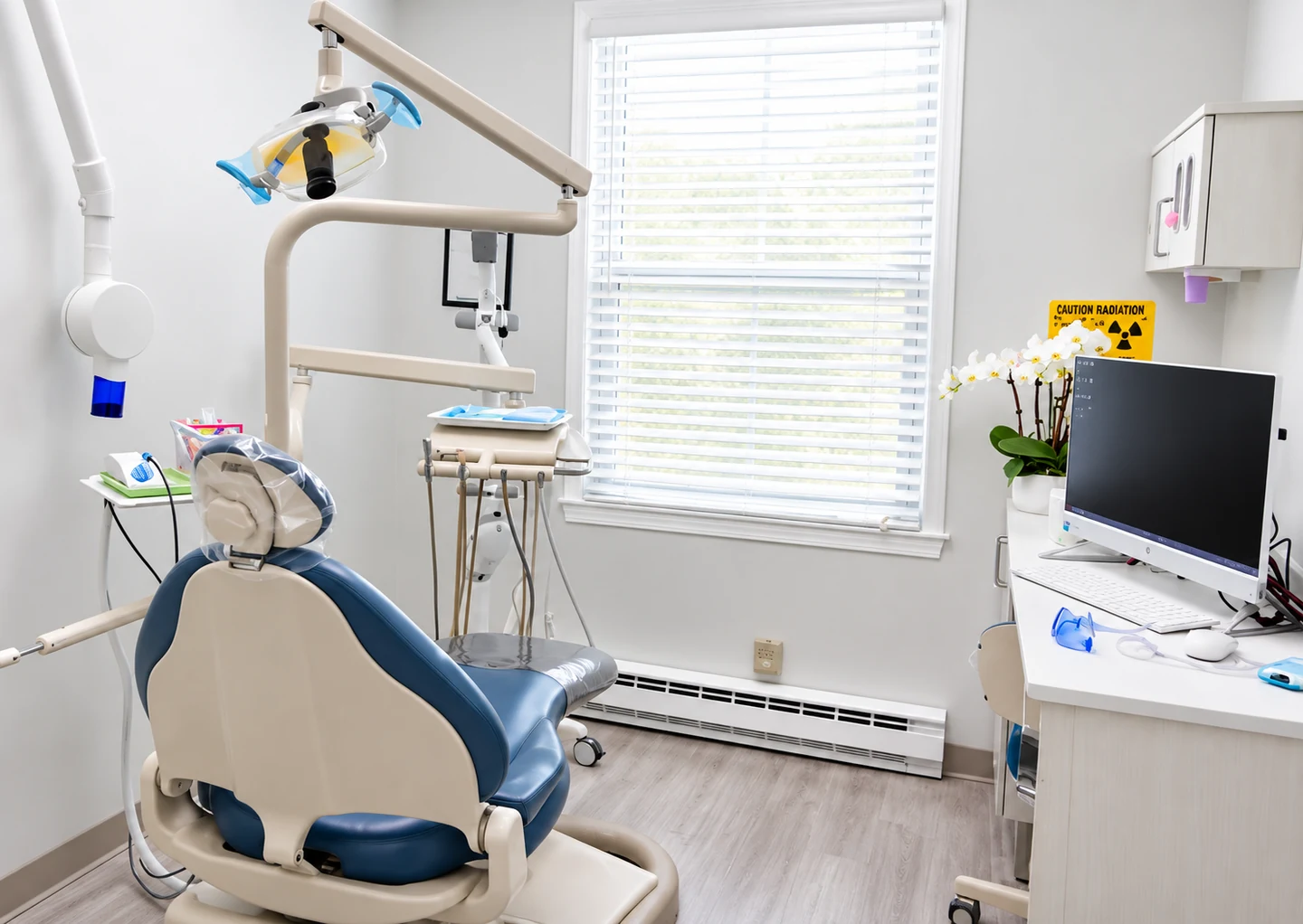 A treatment room with the chair, operatory light and monitor
