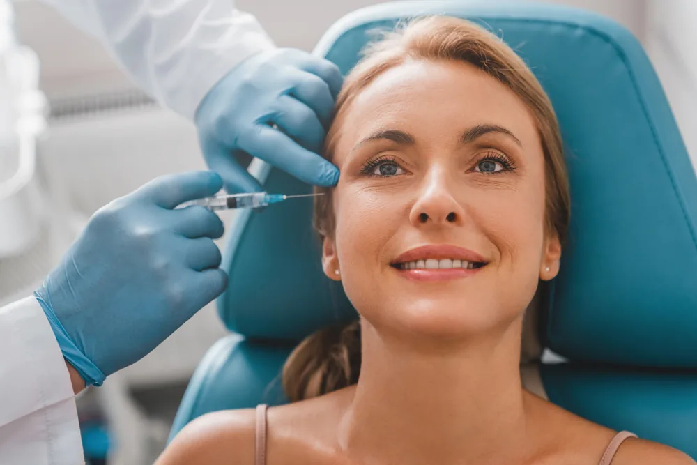 A relaxed, smiling woman in a treatment chair having Botox